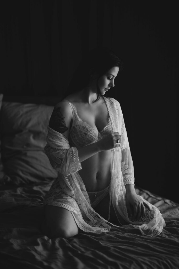 Braut sitzt in Dessous auf dem Bett